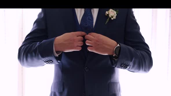 Groom Getting His Blue Suit on Point for the Wedding