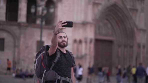 Male Backpacker Sends a Selfie to His Friends Group Chat in Front of Valencia's Cathedral