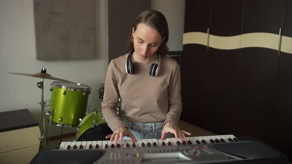 Lady Practices Playing Synthesizer in Studio By Drumkits