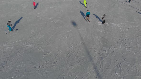 Skiers and Snowboarders on Snow Slope of Resort in Mountains at Winter Day Aerial View Sport and