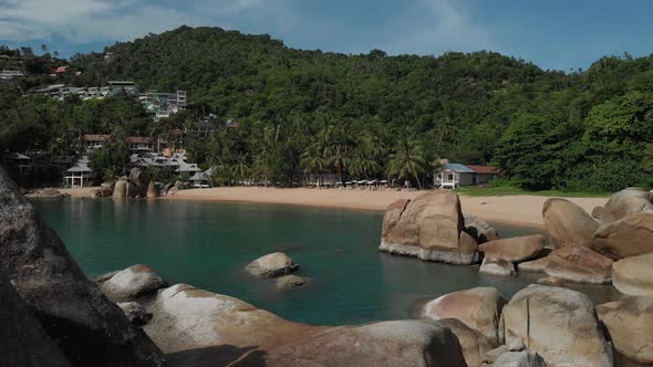 Beach Resort with Turquoise Water and Beautiful Stones Palm Trees and Mountains on Koh Tao Thailand