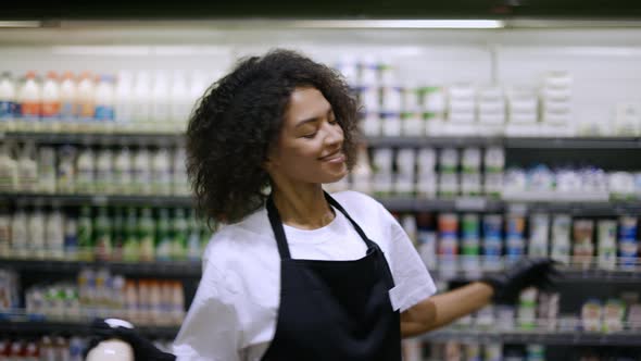Cheerful Worker in Black Apron Dancing in Supermarket Having Fun During Work