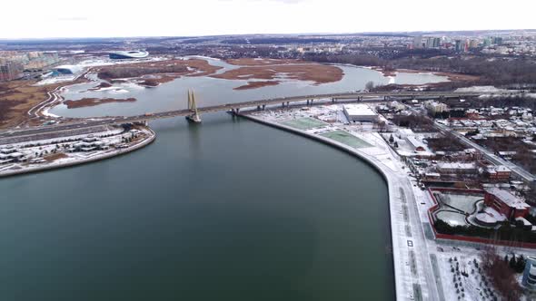 Transport Bridge with Arch Over Calm River with Snowy Banks