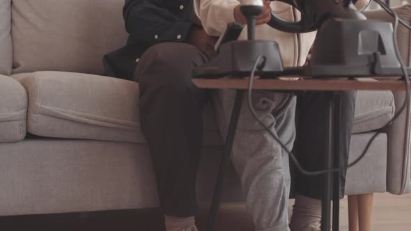 African American Father and Son Playing Race Video Game with Wheel