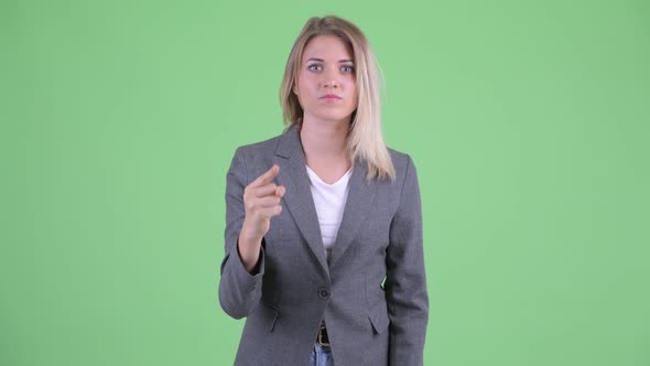 Angry Young Blonde Businesswoman Pointing at Camera