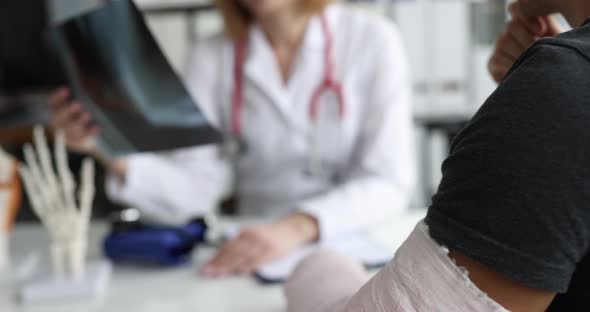 Doctor Examines Xray of Patient with Broken Arm