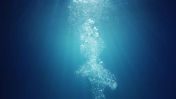 Underwater sunlight beams shining from above coming through the deep crystal clear blue water causin