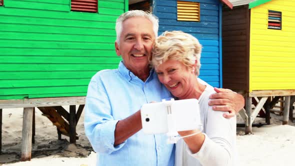 Senior couple taking a selfie on the beach