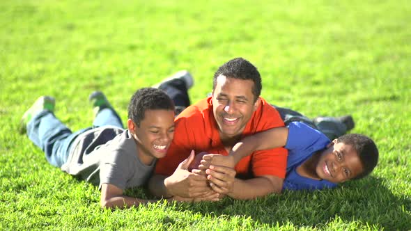 Group portrait of a father and his sons with a football.