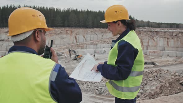 Supervisor Instructing Quarry Worker with Walkie-Talkie