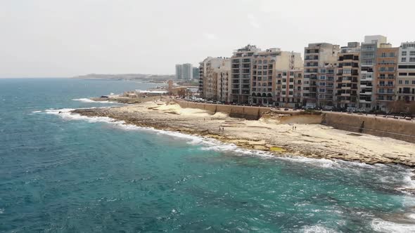 Flying quickly over the Mediterranean Sea revealing the coast of the populated island town of Sliema