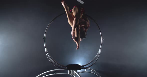 Young Woman in Red Costume is Spinning on a Hoop Gymnastics Show in Studio