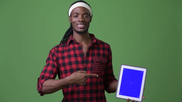 Young Handsome African Man with Dreadlocks Against Green Background