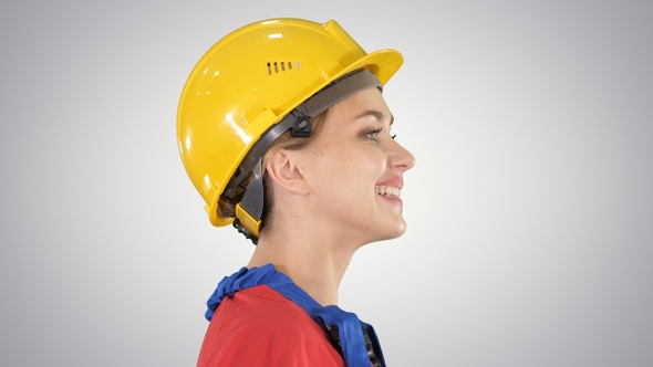 The young woman engineer with yellow safety helmet walking