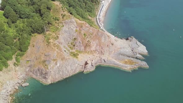 Aerial over head of Cliffside, beside a beautiful Bay