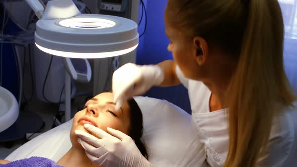 Doctor inserting facial injection on female patient lips