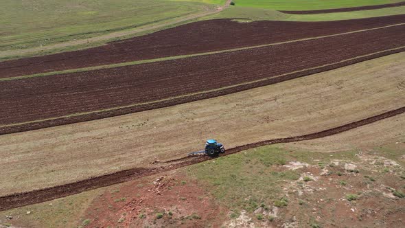 Aerial View Of Tractor Plowing The Field On Farm