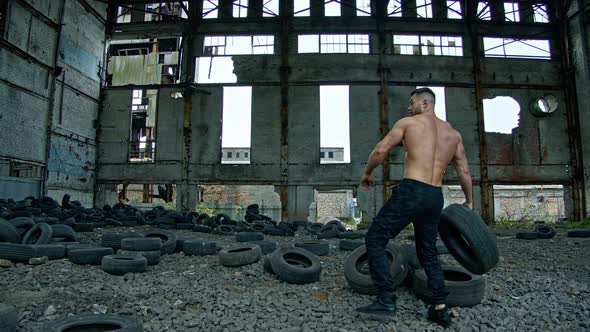 Shirtless man training in ruined plant.