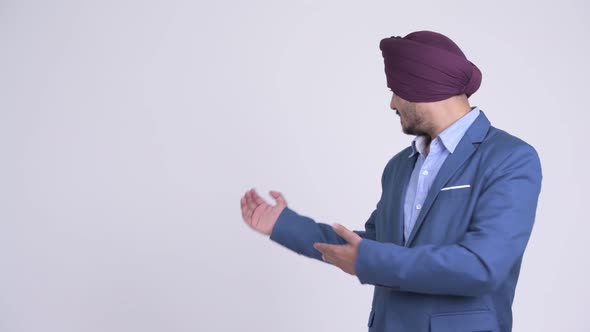 Happy Bearded Indian Sikh Businessman Showing Something