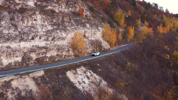 Car Driving on Mountain Slope Near Autumn Trees