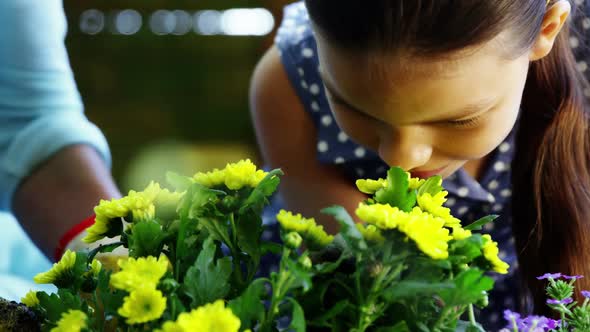 Grandmother and grand daughter smelling flowers