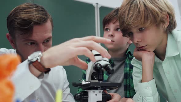 Lesson in a Modern School a Teacher and Children's Look Into a Microscope Studying Biology and