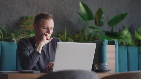 Thoughtful Serious Young Man Student Writer Sit at Home Office Desk with Laptop Thinking of