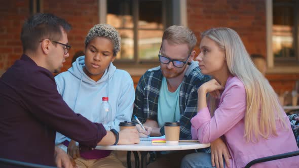 Young Multiethnic Friends Have Fun Studying in Outdoors Cafe Together