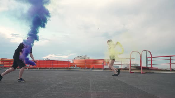 Slow Motion Young Peoples Doing a Handstands Man Makes a Flips Multi Colored Smoke Bombs on a