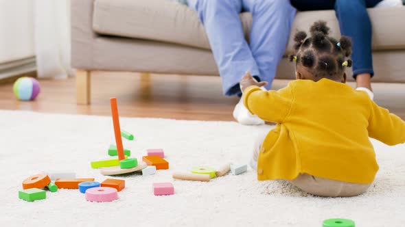 African Baby Girl Playing with Toy Blocks at Home