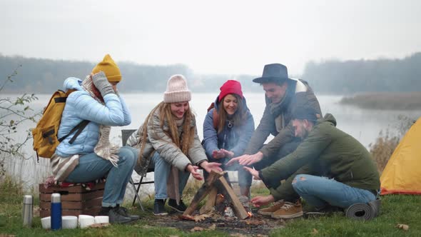 Hungry Travelers Are Cooking Marshmallow on Fire and Eating It From Sticks During Conversation