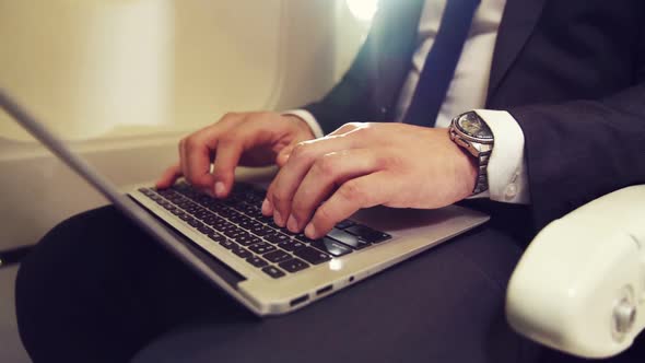 Young Businessman Using Laptop Computer in Airplane