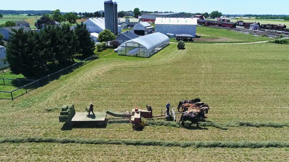 Aerial View of An Amish Farmers Harvesting There Crops With Five Horses Pulling There Baler