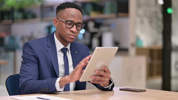 Serious Professional African Businessman Using Tablet in Office