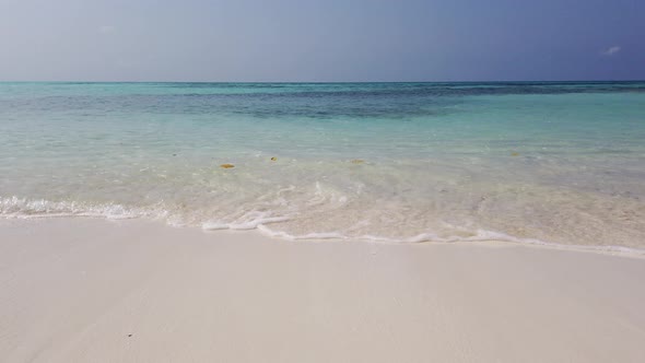 Beautiful fly over clean view of a paradise sunny white sand beach and blue sea background in colour