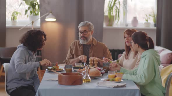 Happy Family Eating Dinner and Having Discussion at Home