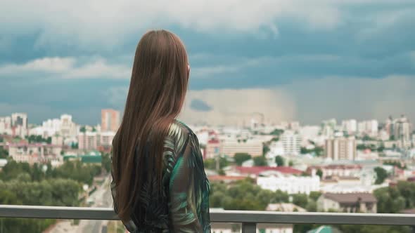 Stylish Long Haired Woman Looks at City From Viewing Deck