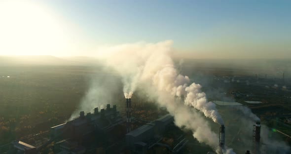 Smoking Chimneys of Industrial Plant at Sunset