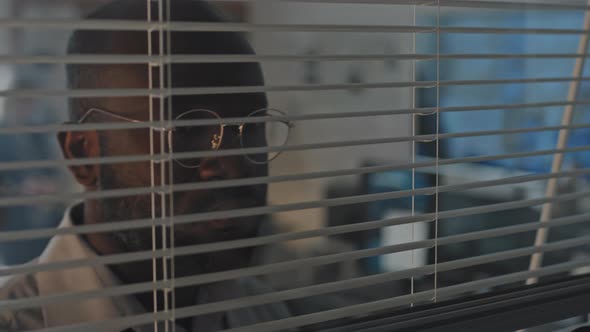 Man Peeking Through Blinds