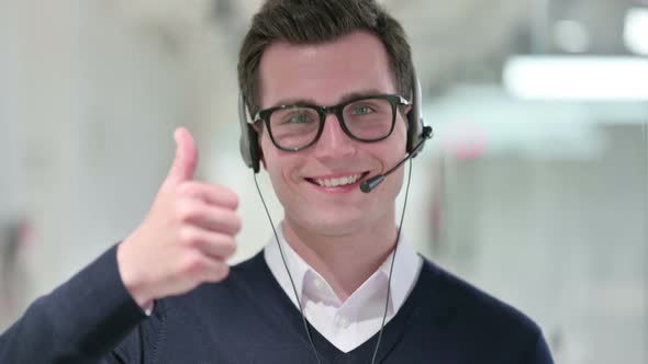 Young Businessman with Headset Showing Thumbs Up 