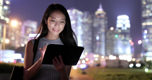 Woman Using Tablet Computer in Hong Kong City at Night 