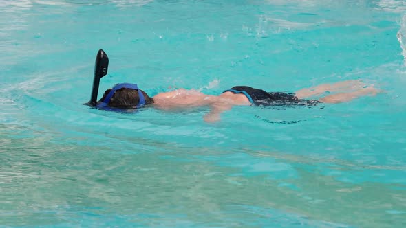 Boy Floats on the Blue Surface