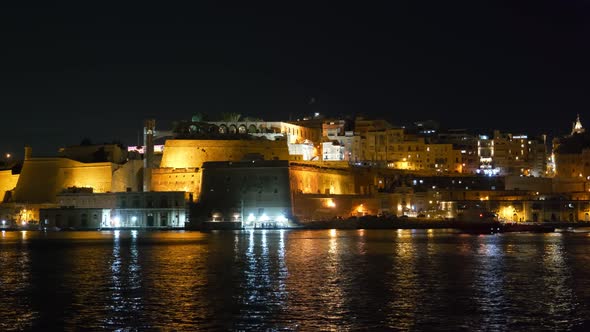 Fortified old city of Valletta at night, capital of Malta, view from the Grand Harbour in the Medite
