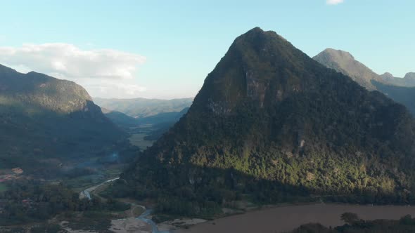 Aerial: flying over Nam Ou River Nong Khiaw Muang Ngoi Laos, sunset dramatic sky