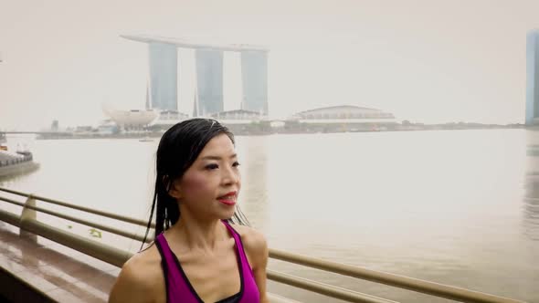 Middle-aged Asian woman jogging in the rain in Singapore 