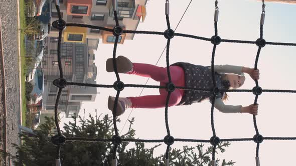 Cute Little Girl Climbing in Playground