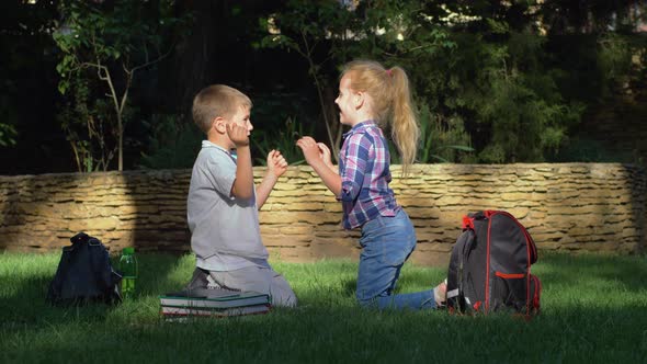 Cheerful Schoolboy and Schoolgirl Playing Clapping Game Sitting in Park After Teaching on School