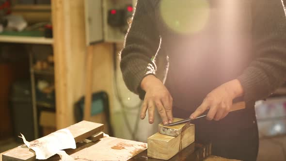 Bladesmith grinding a knife on grindstone