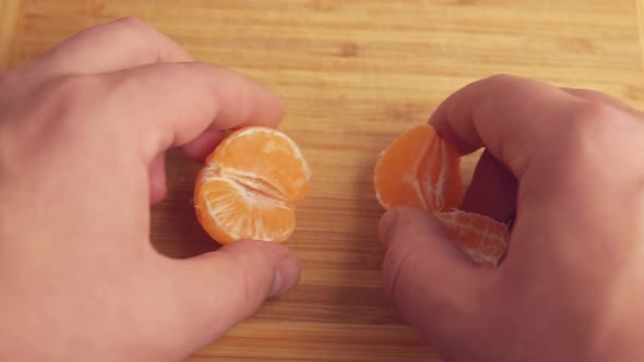 A Man Peels a Tangerine