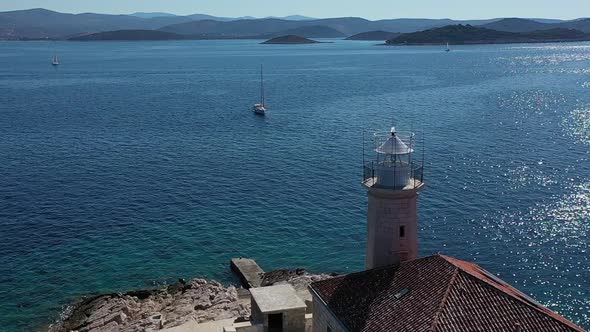 Aerial View of Lighthouse Tower on Small Island and Sailing Boat in Blue Sea on Sunny Day With Croat